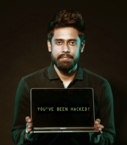 Computer hacker holding open a laptop that reads you've been hacked on its screen